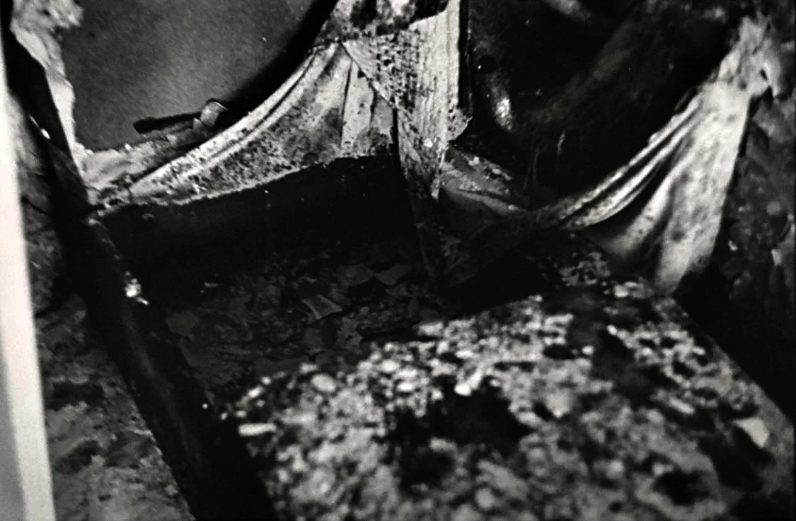 Close-up of a damaged or burnt electrical wire or conduit with tangled, charred material.
