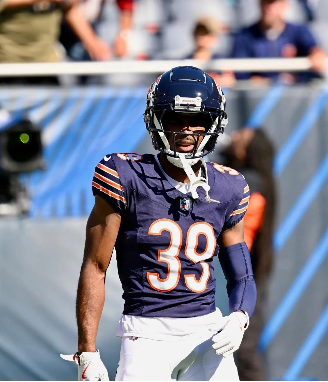 An NFL football player wearing a navy blue Chicago Bears jersey with the number 39, black helmet, and white gloves, standing on the field during a game.