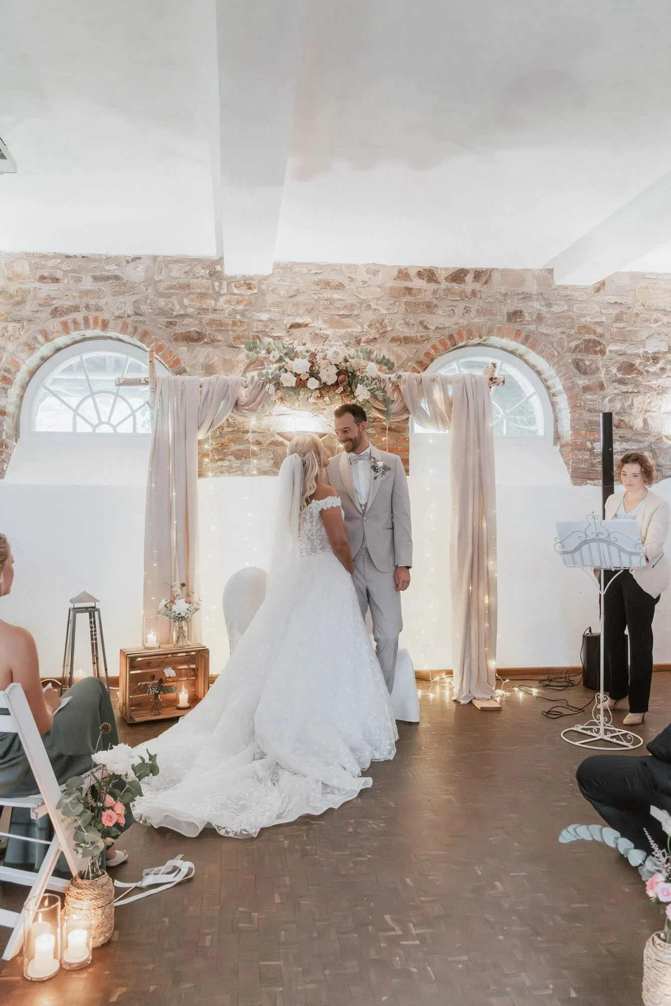 Hochzeitszeremonie mit Brautpaar und Traurednerin