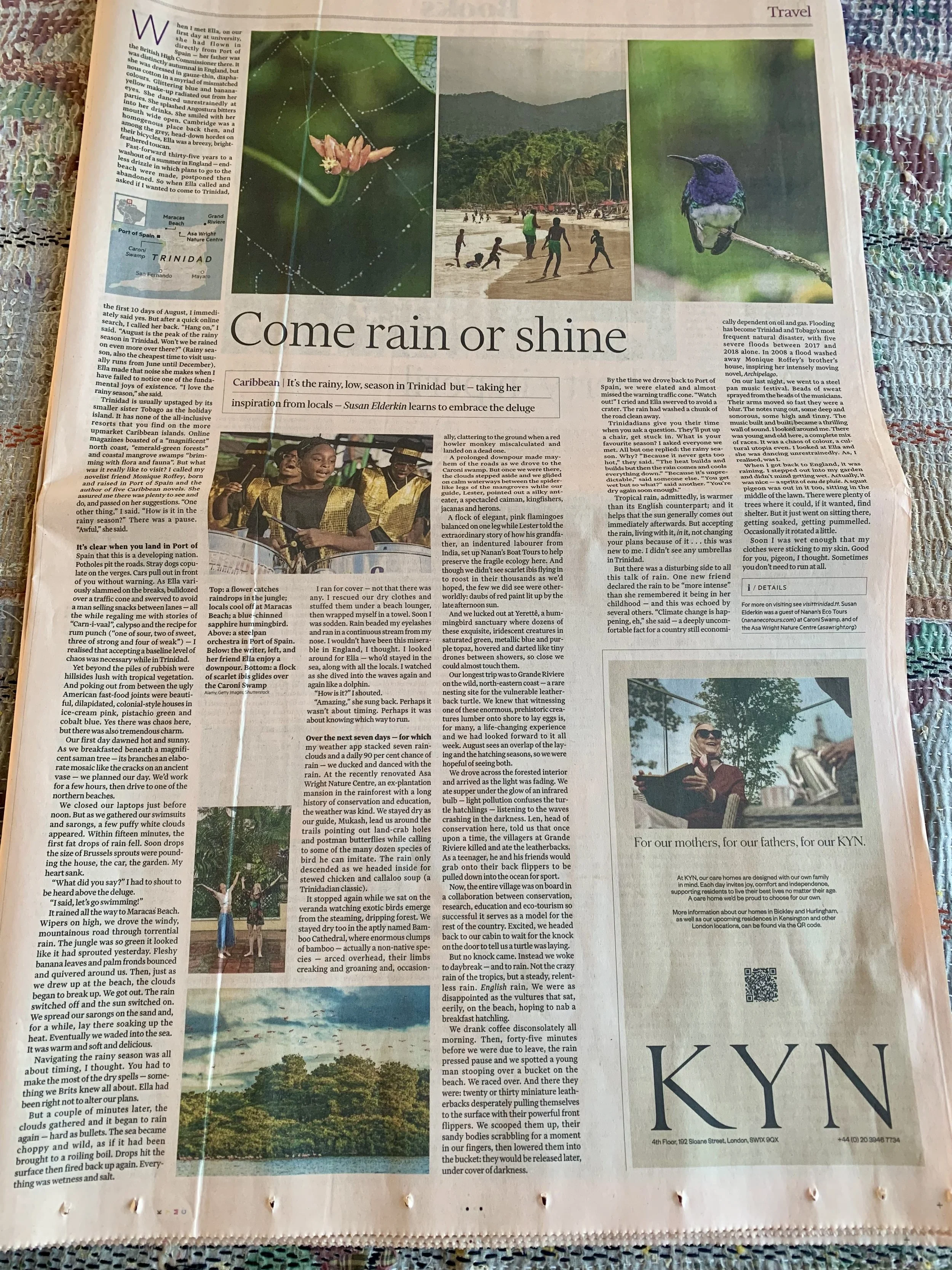 Travel article about Trinidad featuring a collage of four images: a pink flower, a beach with children playing, a lush green mountain, and a purple hummingbird. A woman and a child are also shown, enjoying the outdoors. An advertisement for KYL is at