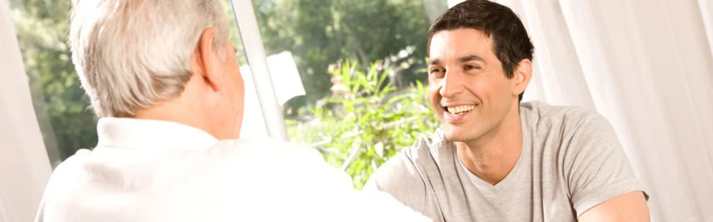 Male volunteer speaks with an older gentleman