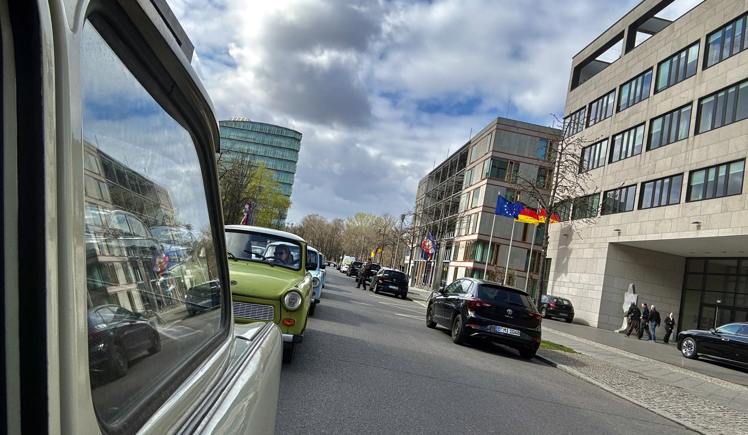 View from inside a Trabant car driving in a convoy through Berlin streets