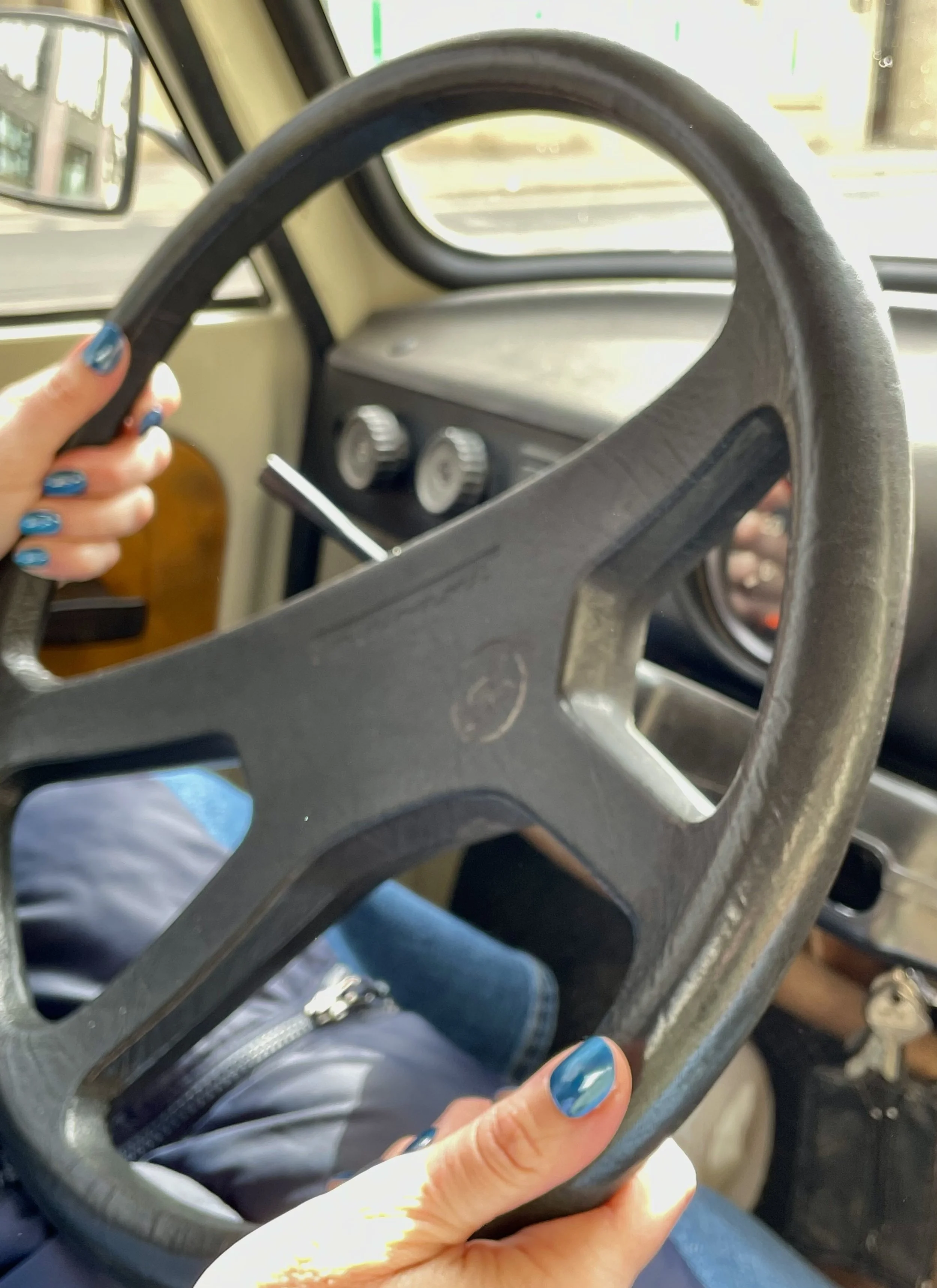 A women's hands holding a Trabi steering wheels