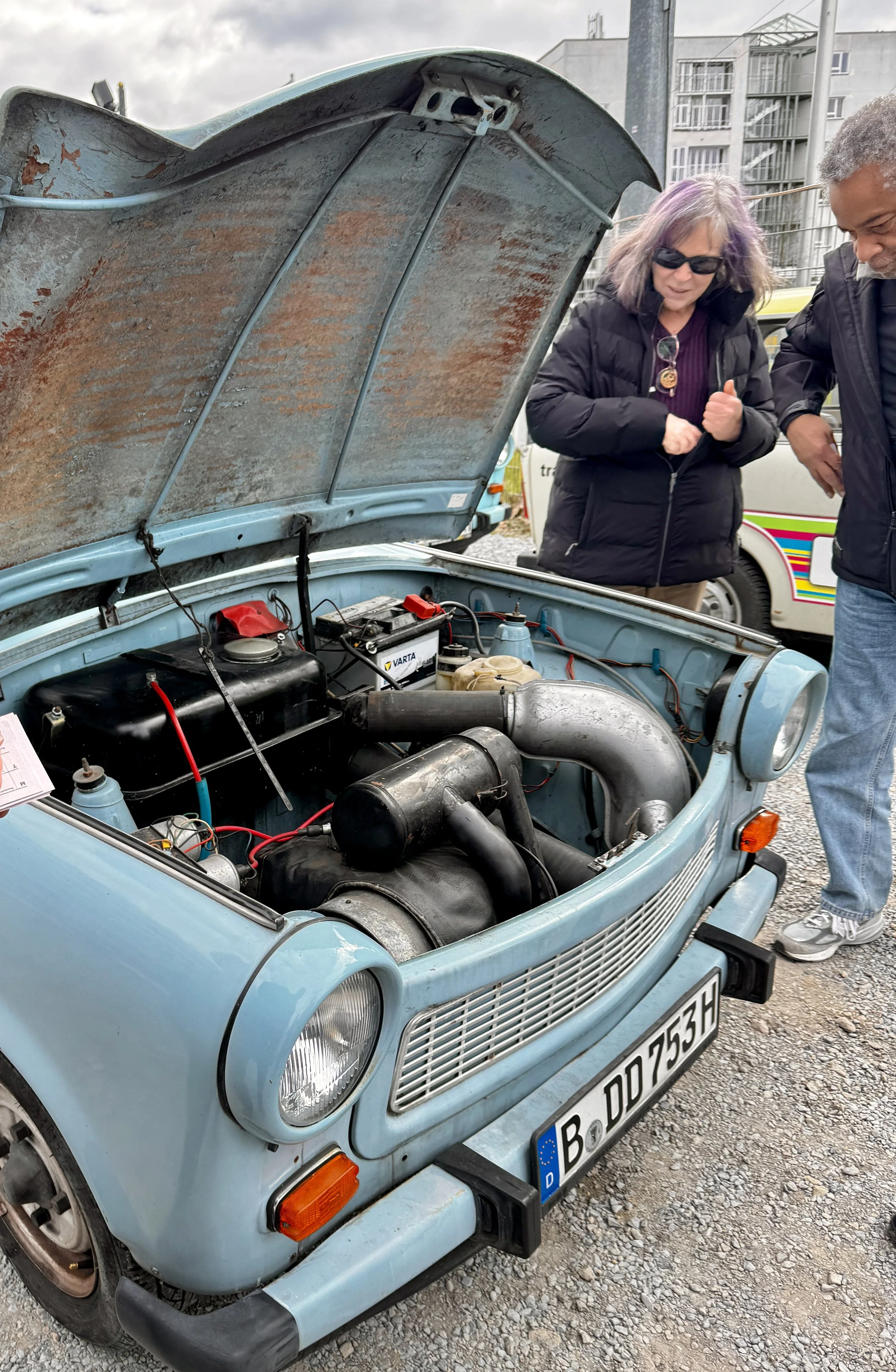Open hood of a Trabant car showing the simple two-stroke engine during a Berlin Trabi tour