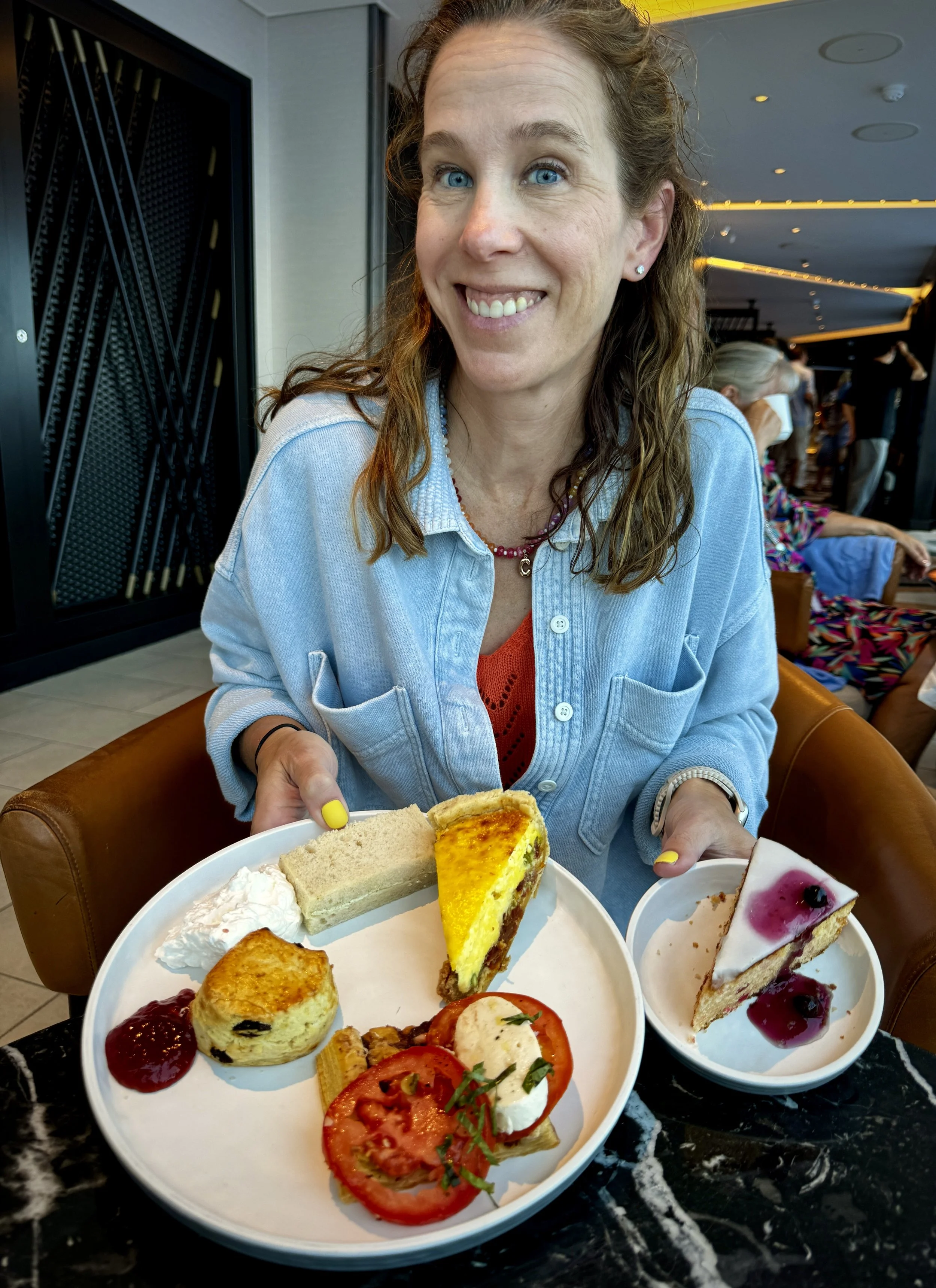 Afternoon tea with scones, sandwiches and desserts in the Observation Lounge aboard Norwegian Viva.