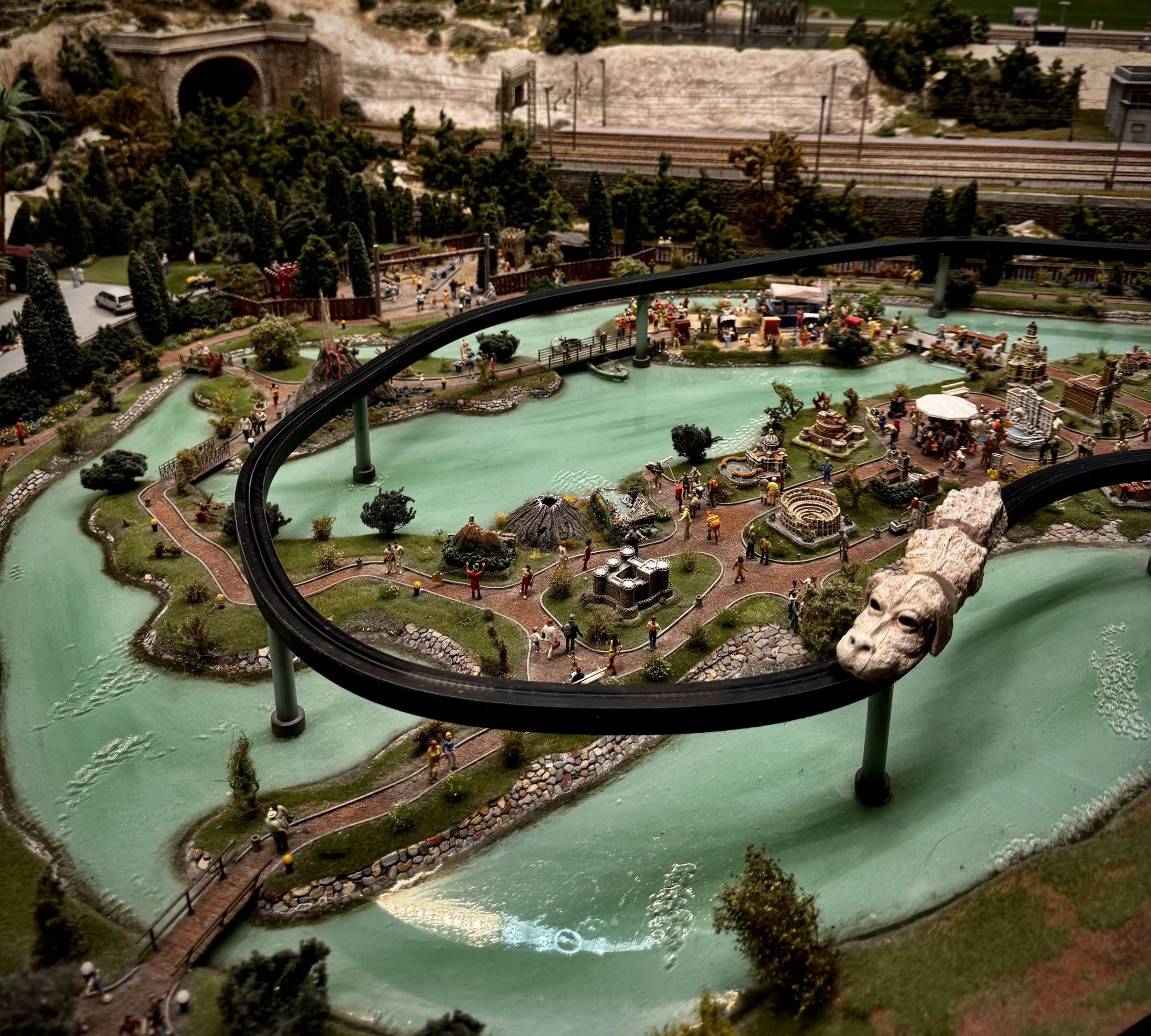 Fantasy-themed miniature landscape at Miniatur Wunderland featuring turquoise waterways, tiny visitors and a monorail shaped like a dragon.