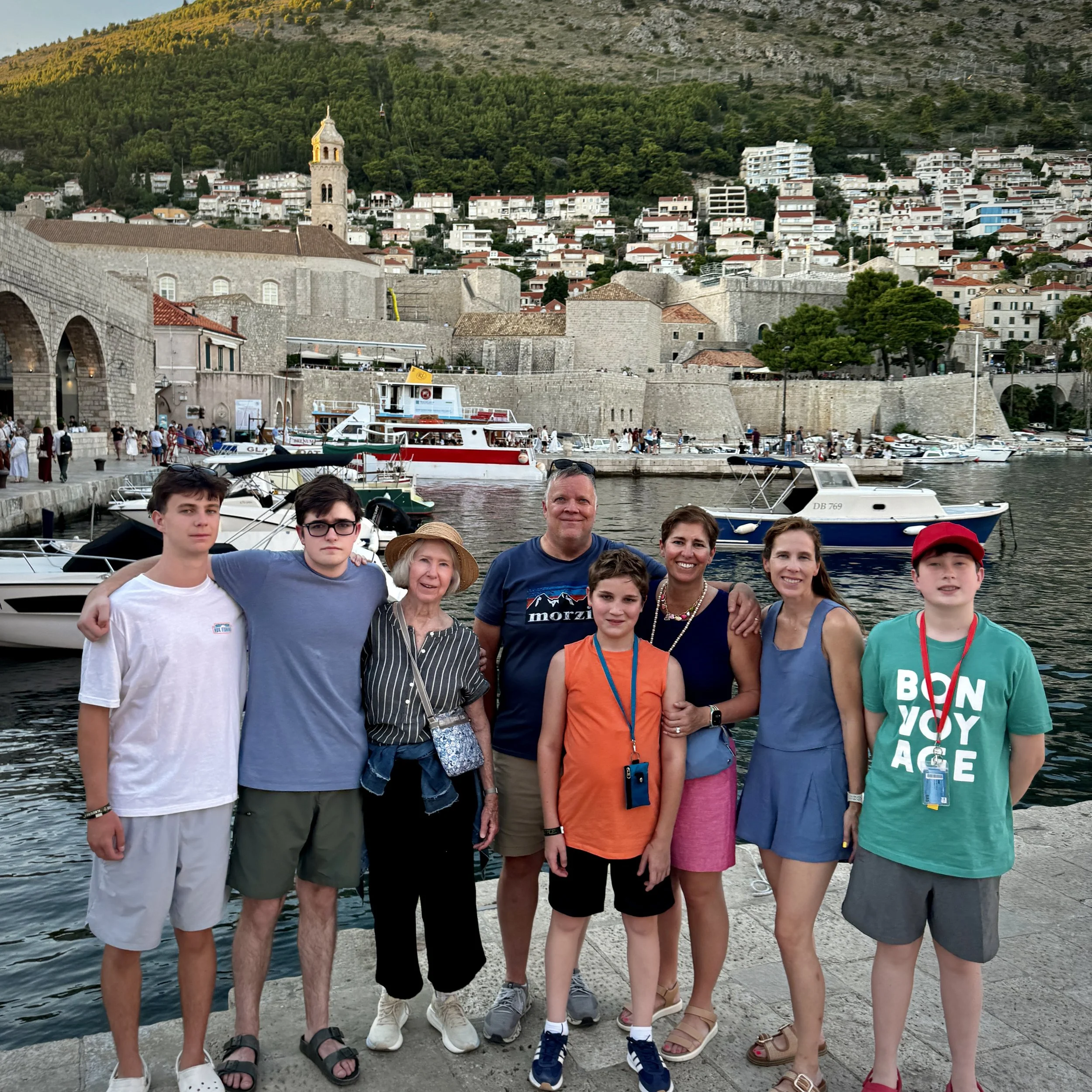 Family group at Dubrovnik's Old Town harbor with the historic city walls in the background.