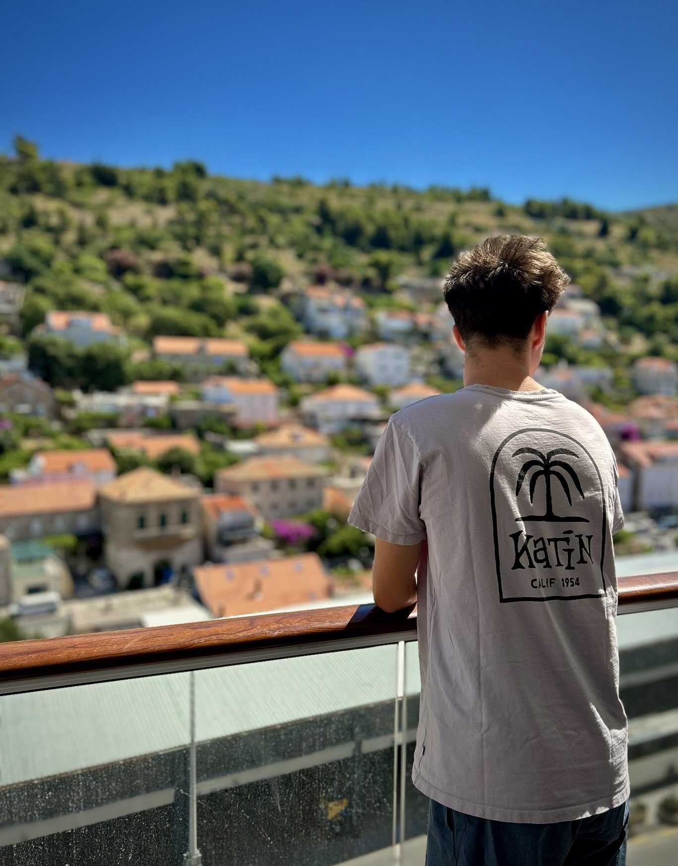 Teen overlooking the red-tiled rooftops of Dubrovnik's Old Town, Croatia.