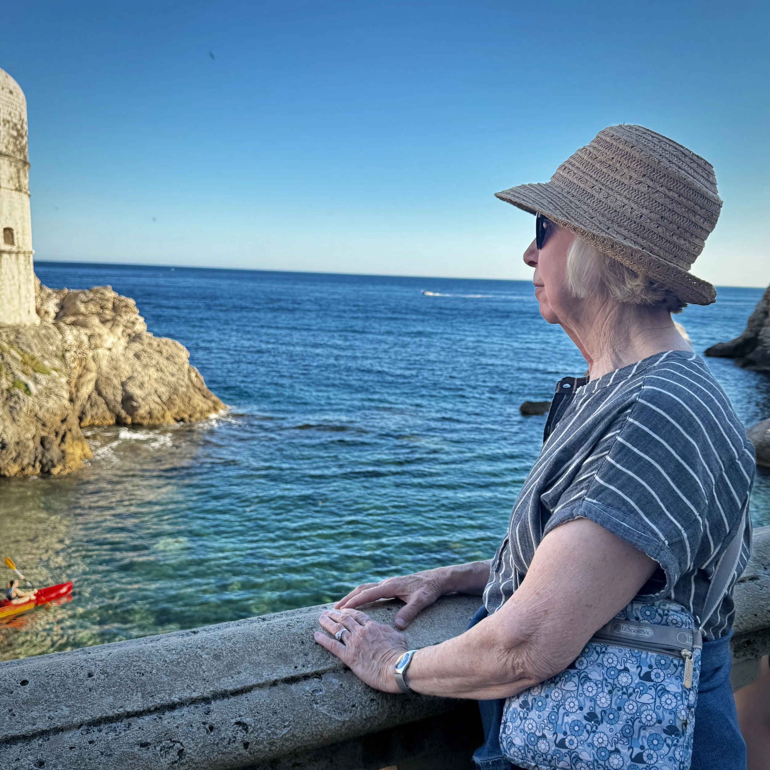 Woman looking out over the Adriatic Sea from Dubrovnik's Old Town in Croatia.