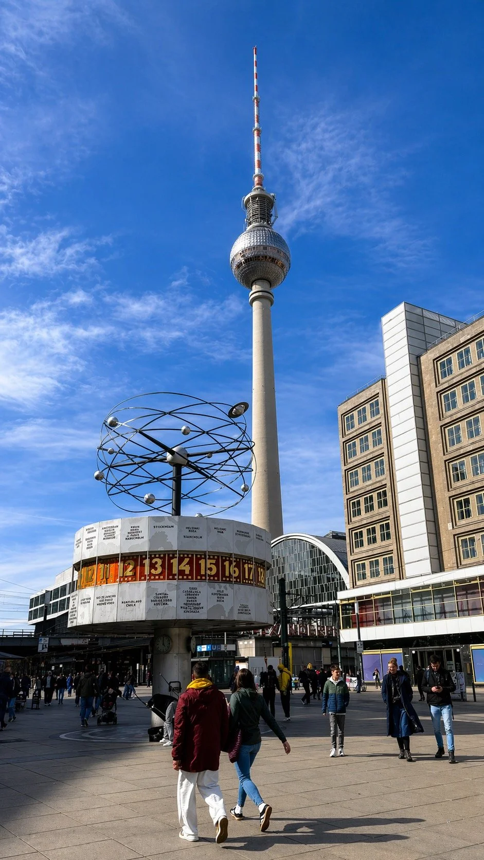 Berlin TV Tower (Fernsehturm) rising above Alexanderplatz with the World Clock and people walking in the square below.