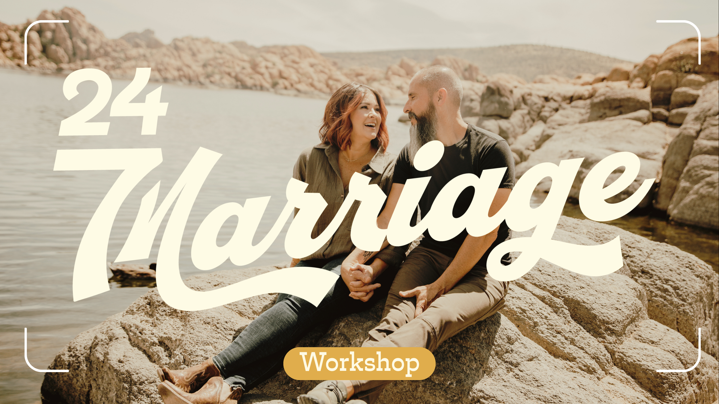 A couple sitting on rocks by the water, smiling and holding hands, during a sunny day near a rocky shoreline with hills in the background, overlaid with text '24-7 Marriage Workshop'.