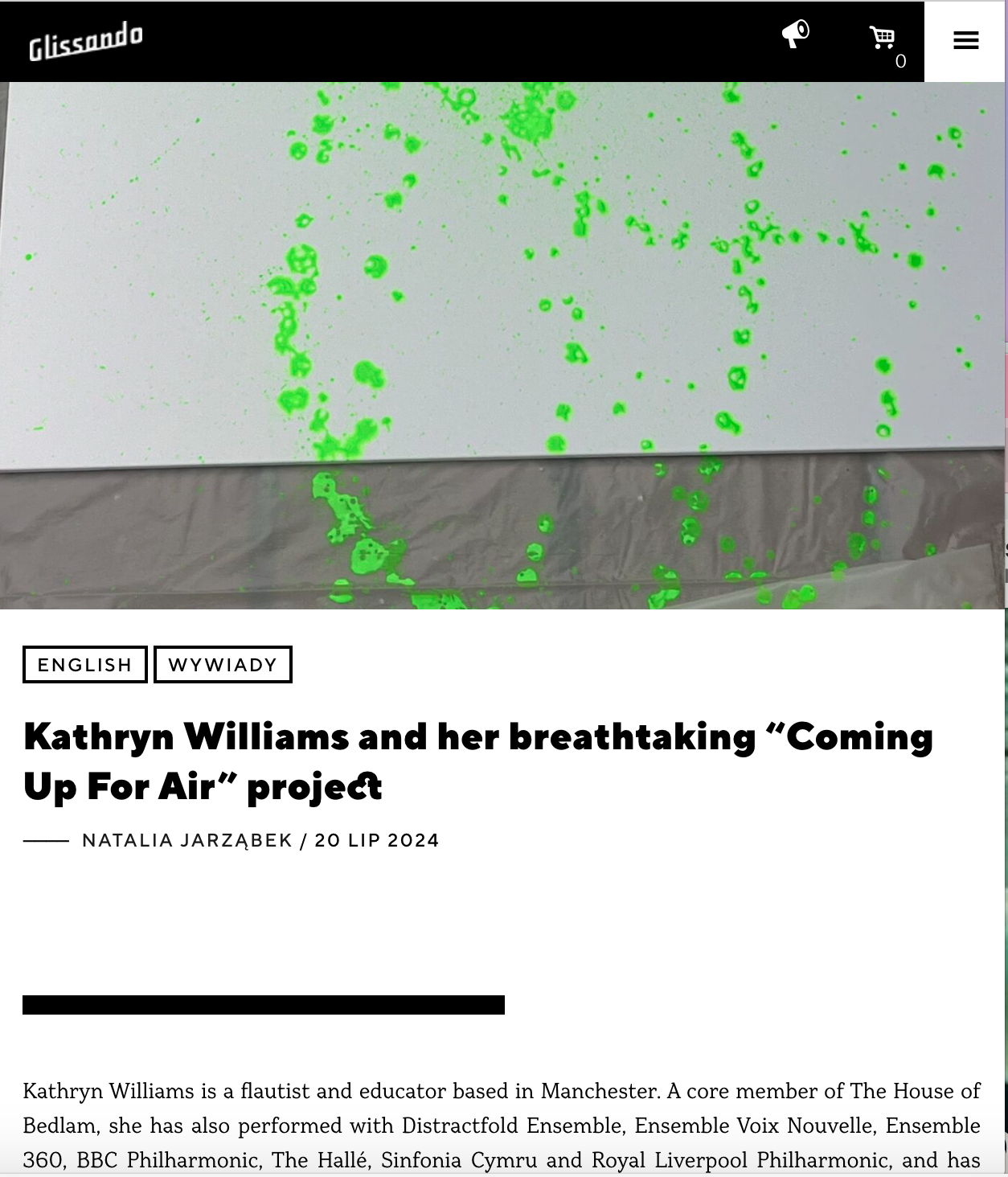 An art installation with green fluorescent paint splattered on a white wall and some on the gray floor.