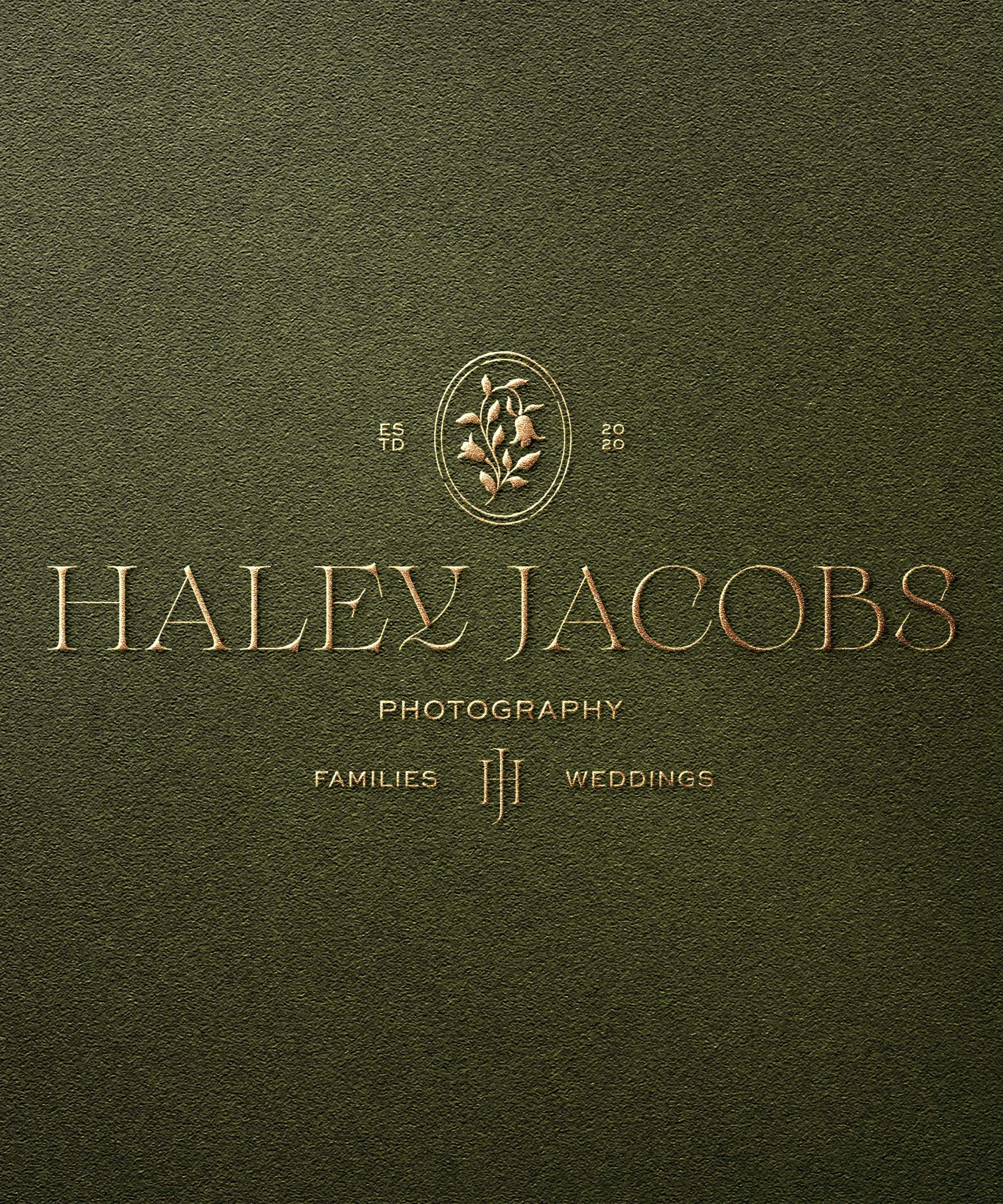Elegant business card for Haley Jacobs Photography on dark green textured background, with gold lettering including name, logo, and services like families and weddings.