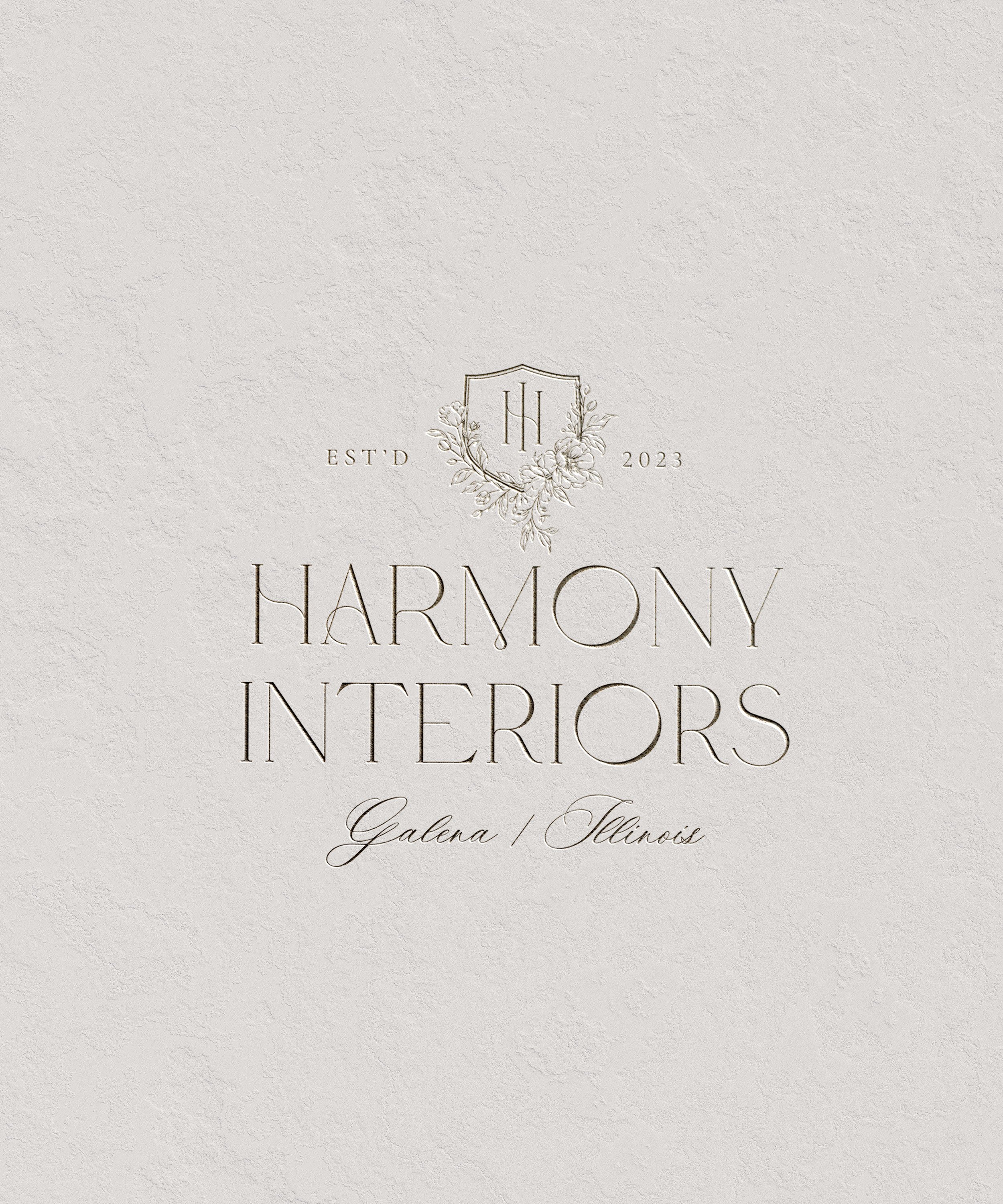 Elegant logo for Harmony Interiors, featuring initials 'H S' inside a shield with floral accents, established 2023, based in Galena, Illinois.