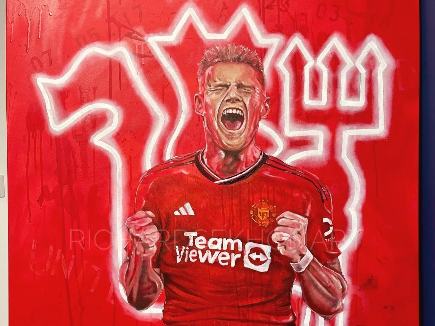 Painting of a footballer celebrating with team logo behind him