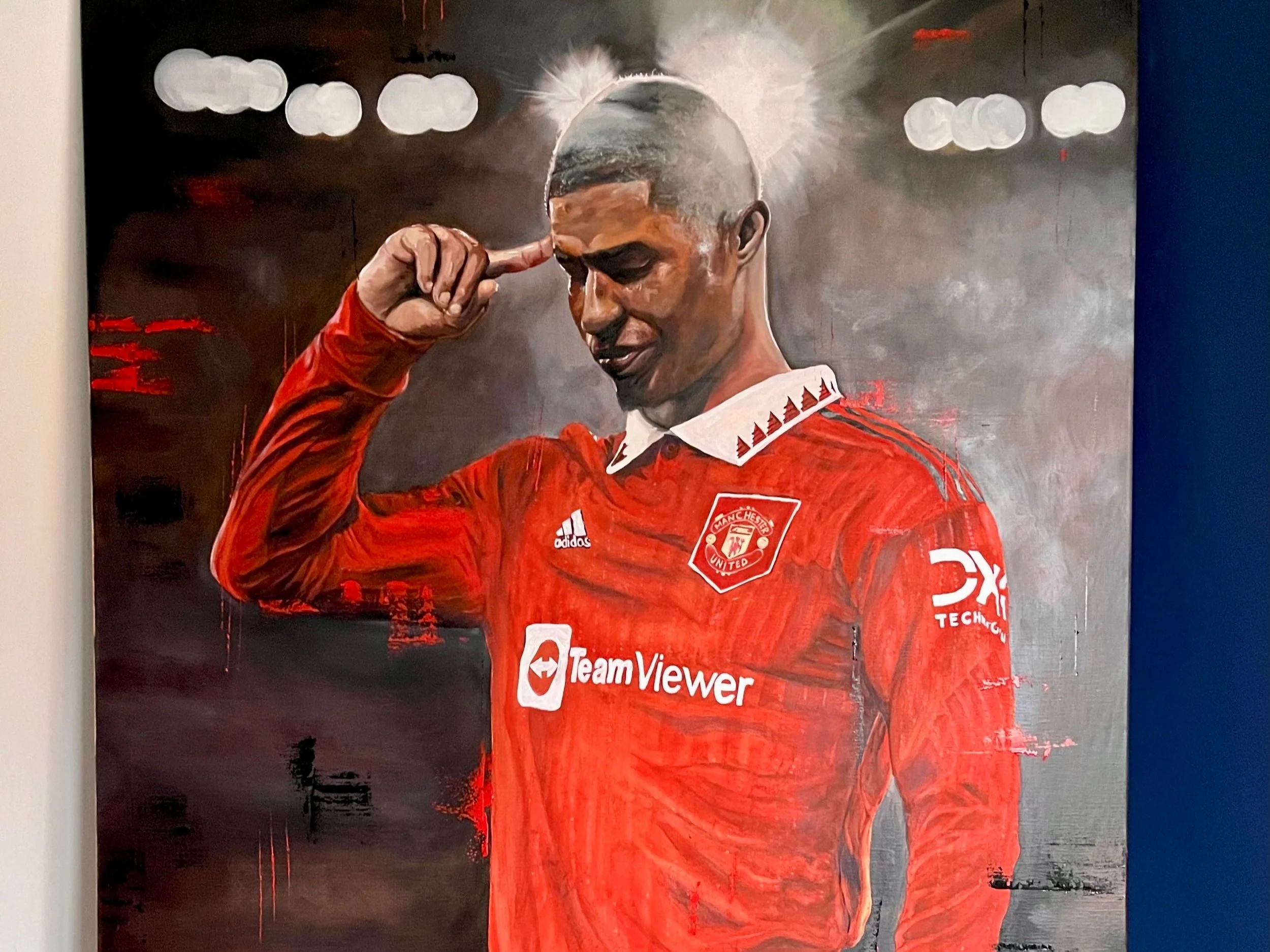 painting of a footballer pointing to his head with his finger