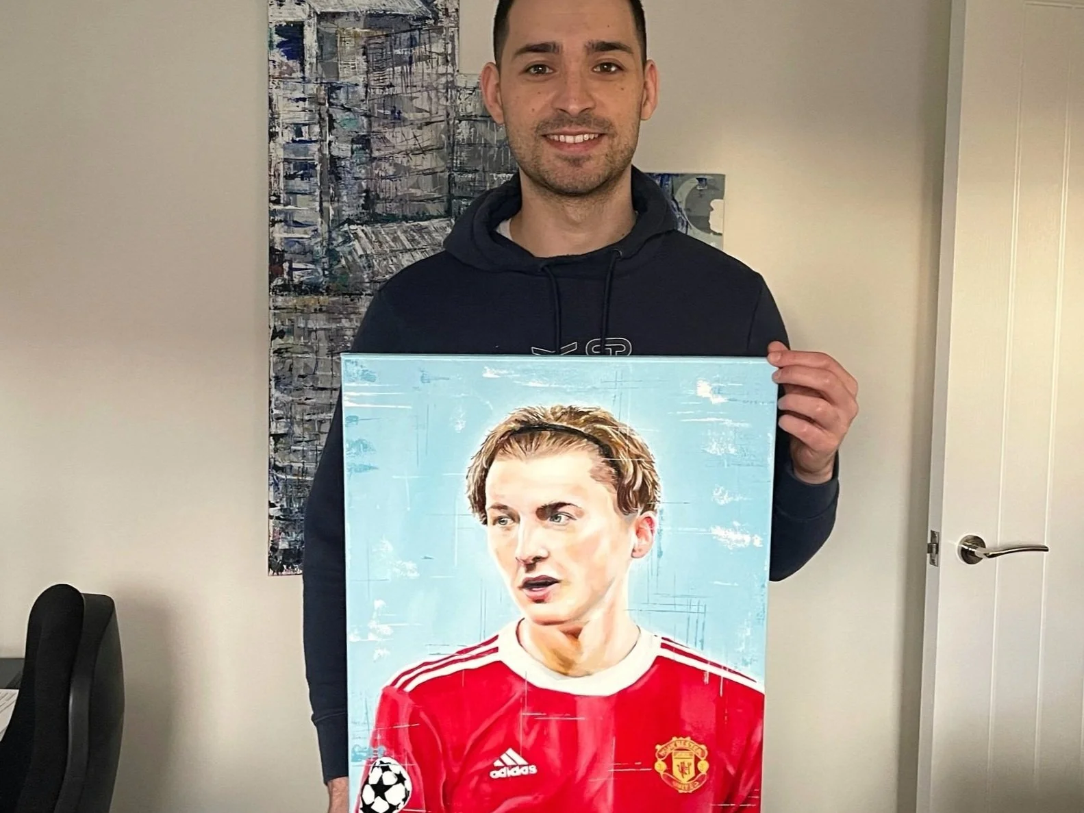 A man holding a portrait of a footballer