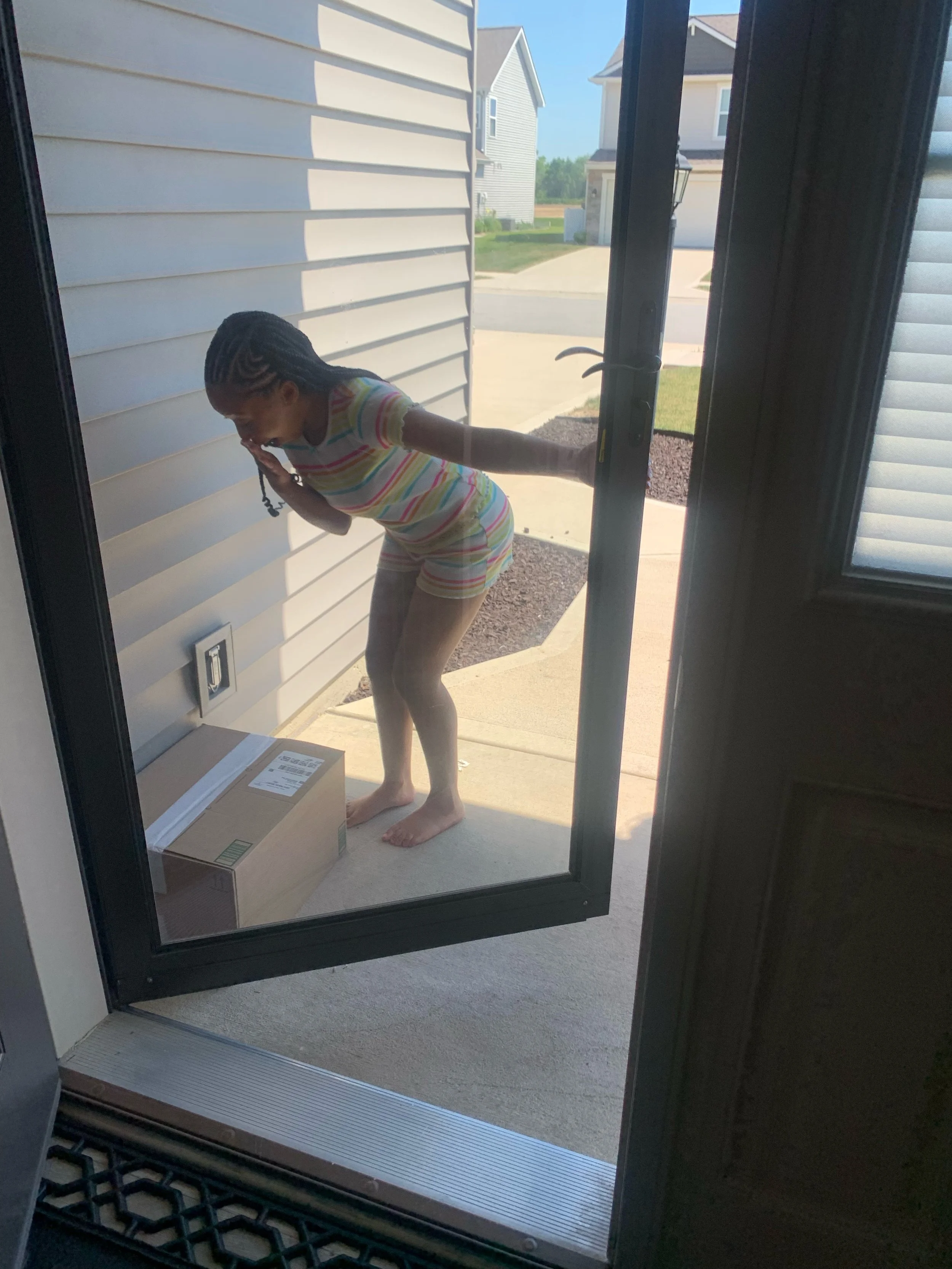 A woman in striped pajamas bending over a package outside her house, looking surprised with her hand covering her mouth. Providing flavorfull homemade lemonade to your doorstep.