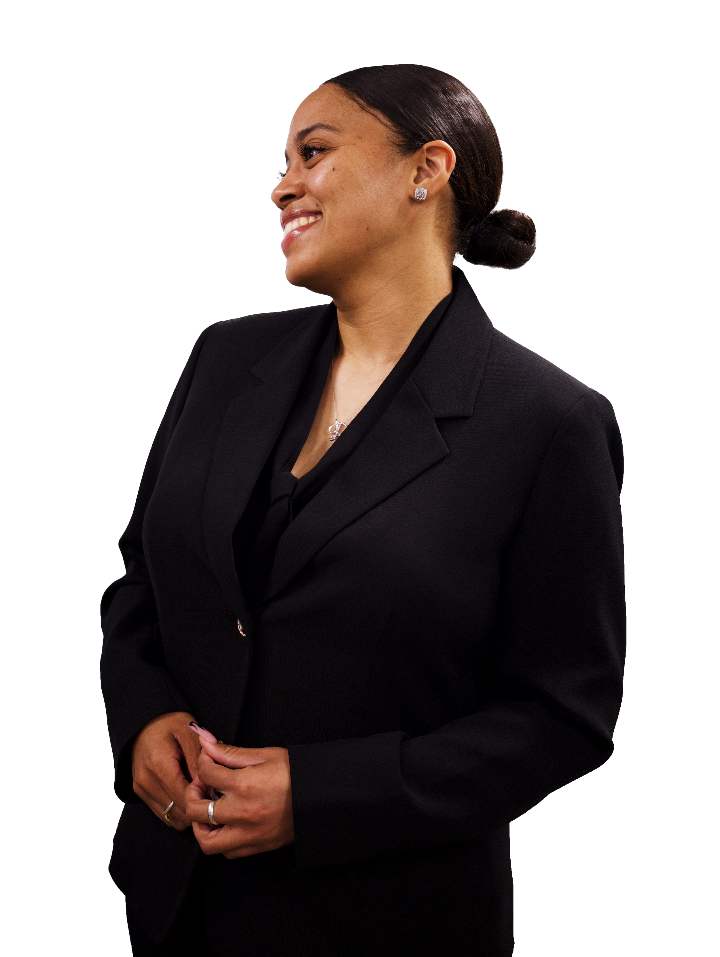 A professional woman in a black suit smiling and looking to her right.