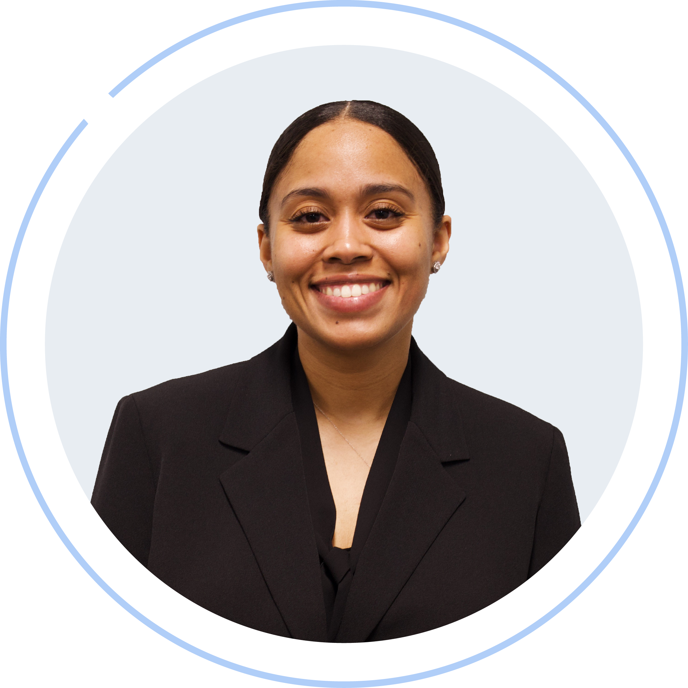 A woman with dark hair styled in a bun, wearing a black blazer and smiling at the camera.