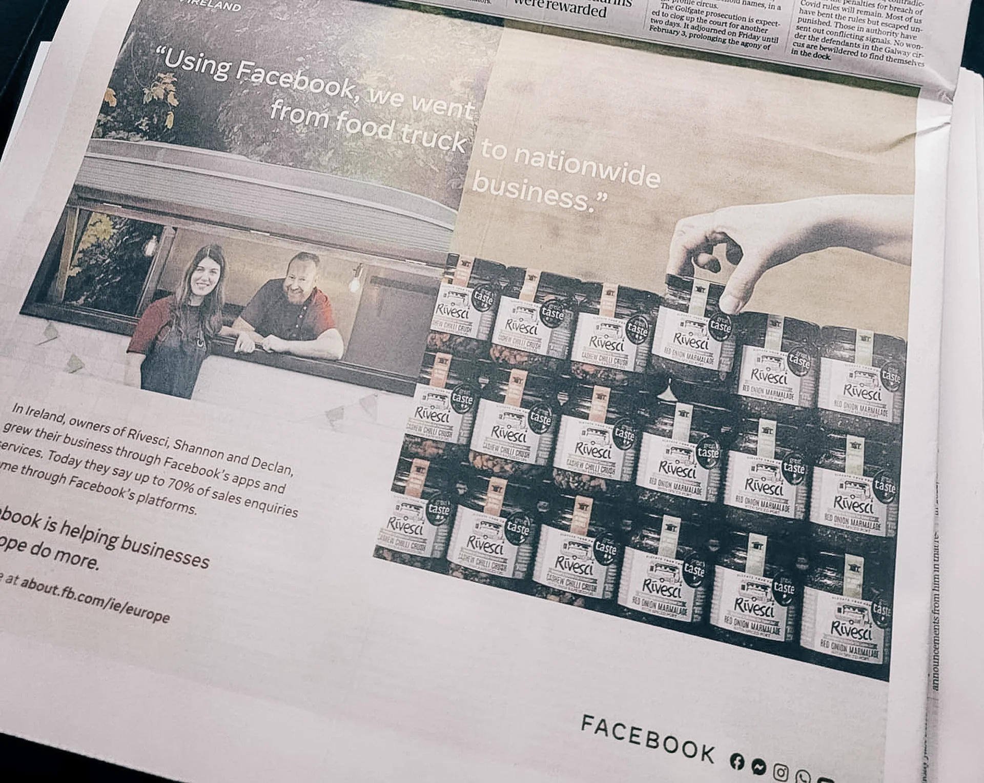 A newspaper advertisement featuring a quote about Facebook helping a food business expand from food truck to nationwide. Shows a photo of two people smiling in front of a food truck and a display of numerous jars of Rivesci chili sauce. Also has a hand holding one jar on the right side of the ad.
