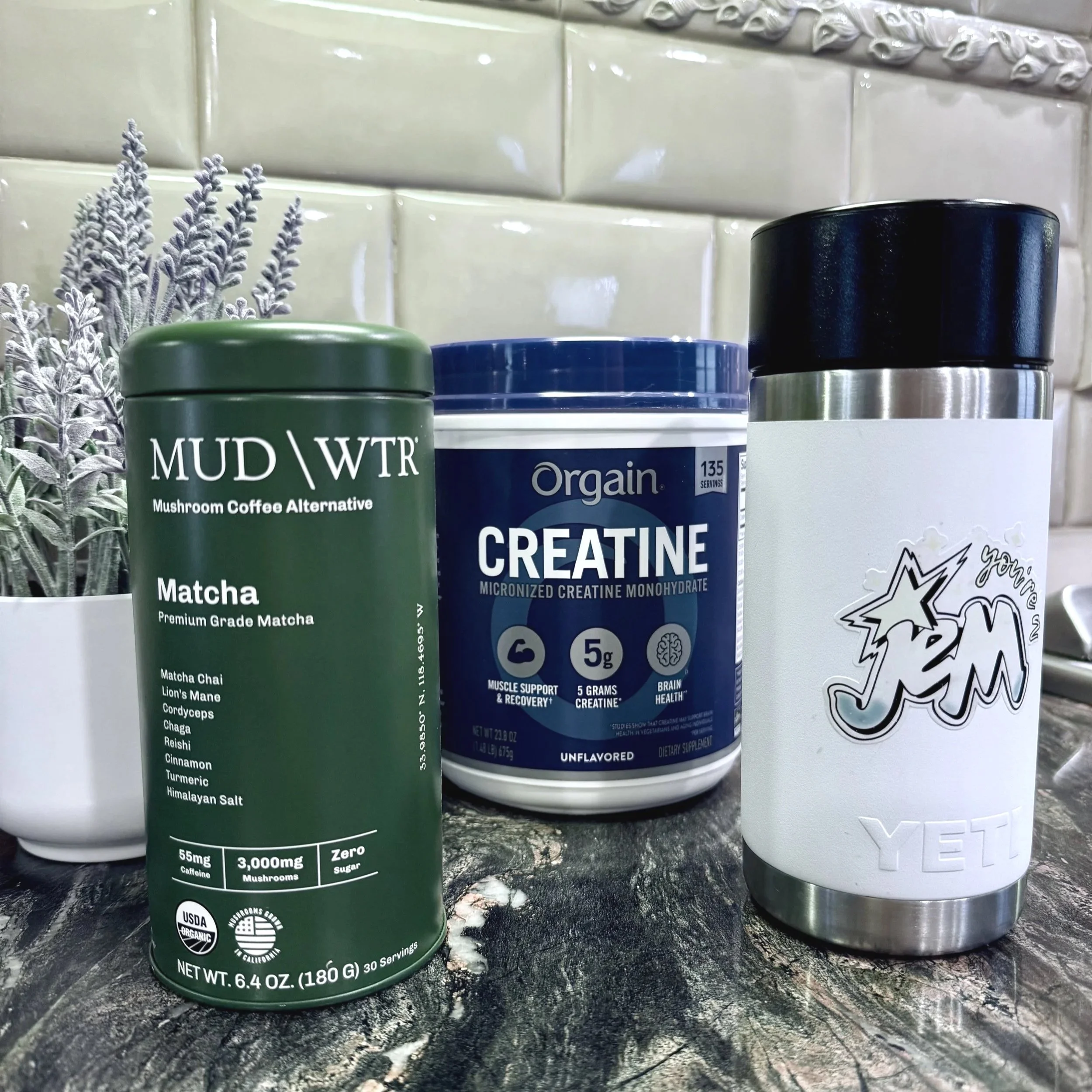 MUD/WTR Matcha, Orgain Creatine, and a Yeti tumbler on kitchen counter.