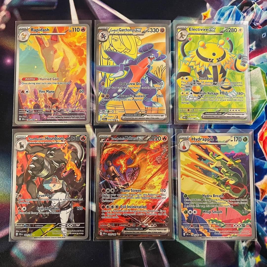 Six Pokémon trading cards laid out on a flat surface. The top row features Rapidash, Cynthia's Garchomp EX, and Electivire. The bottom row includes Team Rocket's Houndoom, Team Rocket's Moltres EX, and Hydrapple.