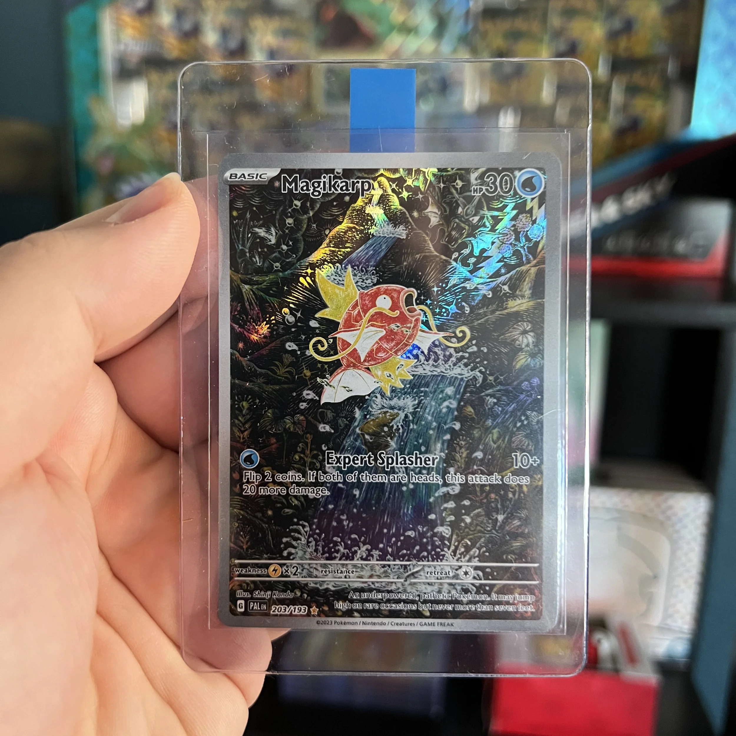 Holographic Pokémon card of Magikarp, with a colorful, shiny background.
