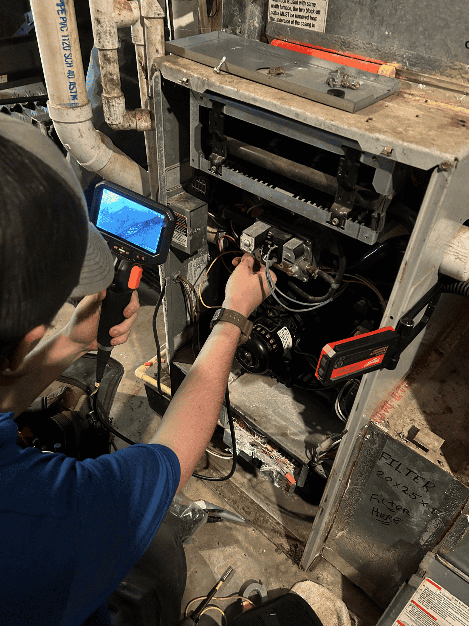 HVAC technician using inspection camera for old furnace