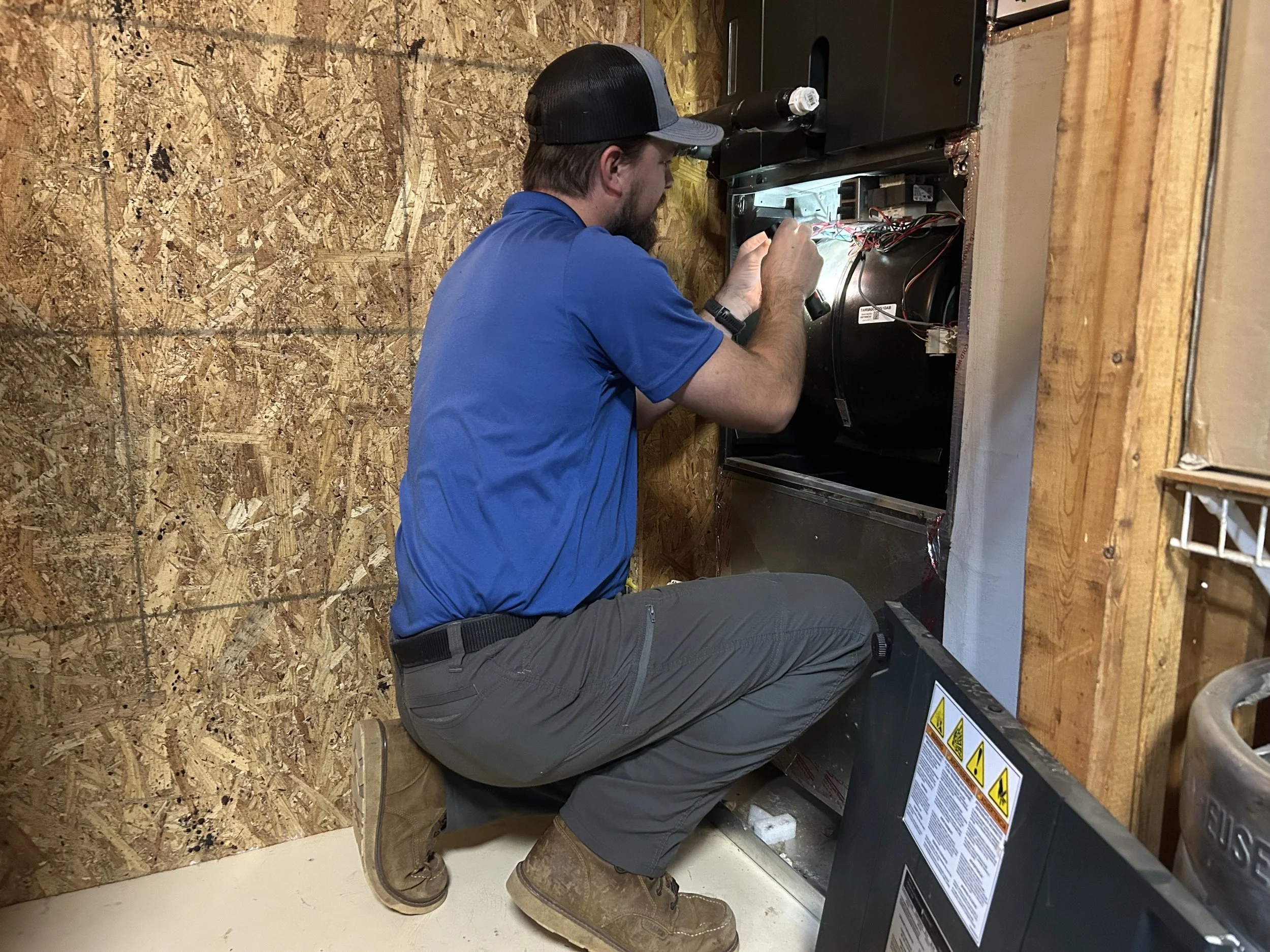 hvac technician repairing furnace