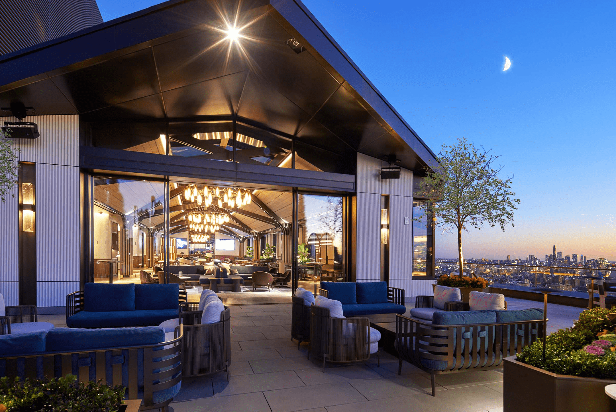 Front of an intricately designed pavilion at 1 Madison New York, NY with beautiful view of Le Jardin restaurant and the New York City skyline at sunset