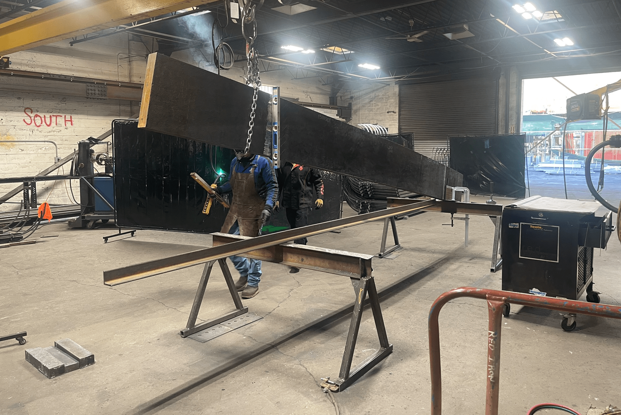 Red ironworks workshop worker's beginning to fabricate the Chase staircase materials