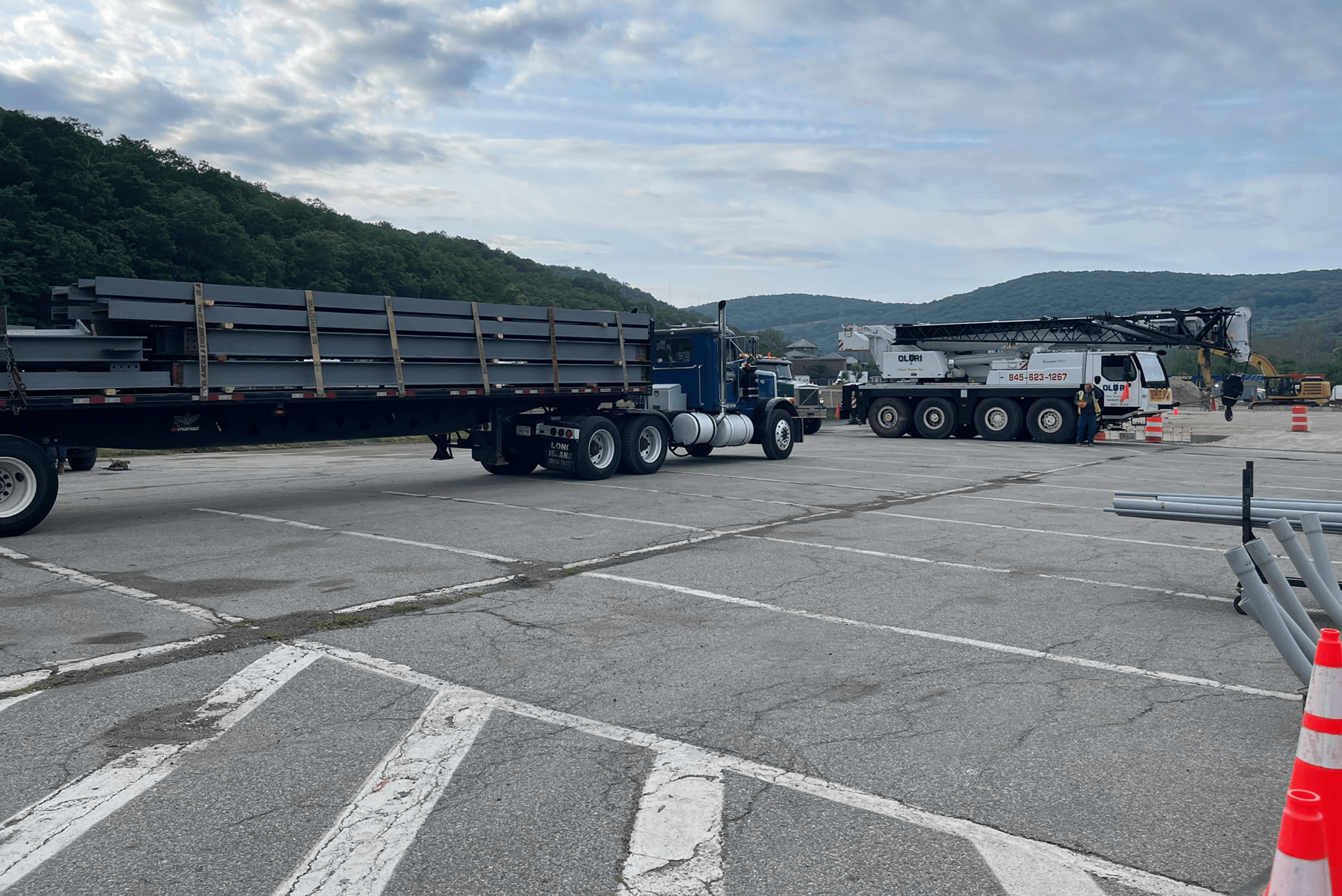 Trucks in a parking lot with massive materials for the project
