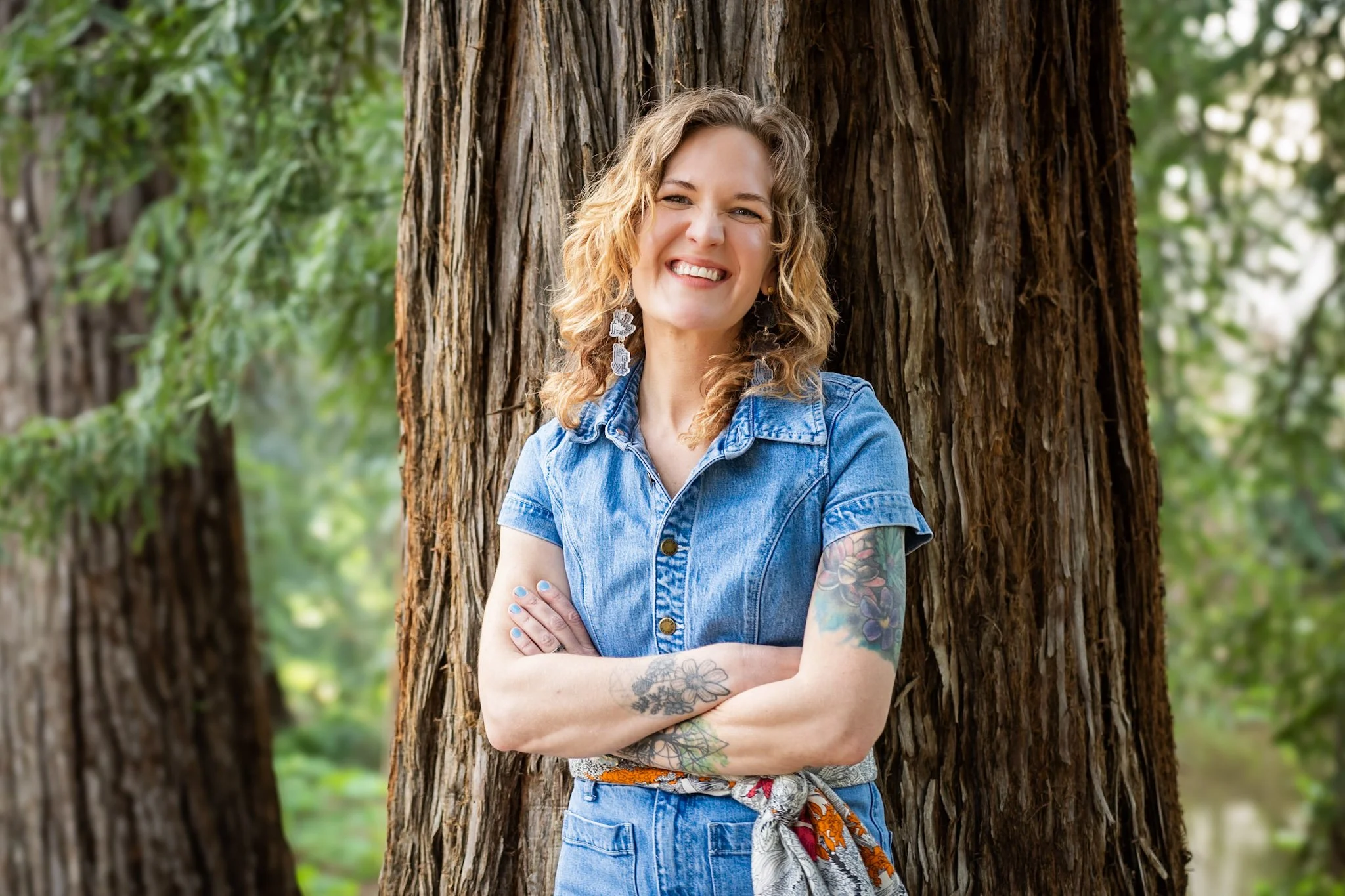 Rebecca Lesesne, LCSW, a Sacramento therapist, smiling outdoors against a redwood tree