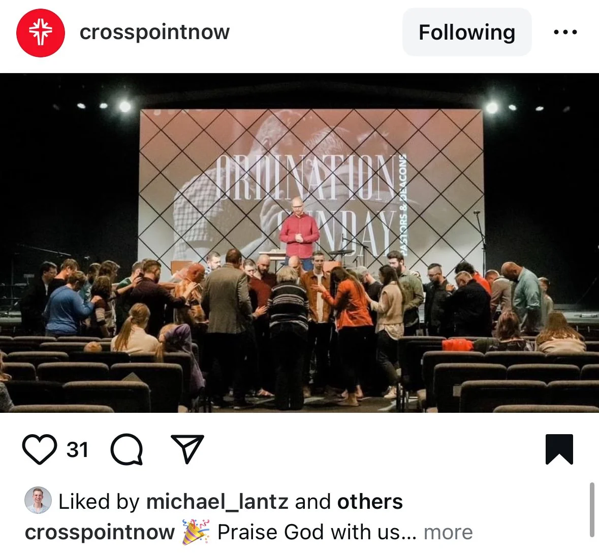Group of people gathered on stage at a Christian event with a large screen behind them displaying the words "Overcoming Day" and a person speaking to the audience.
