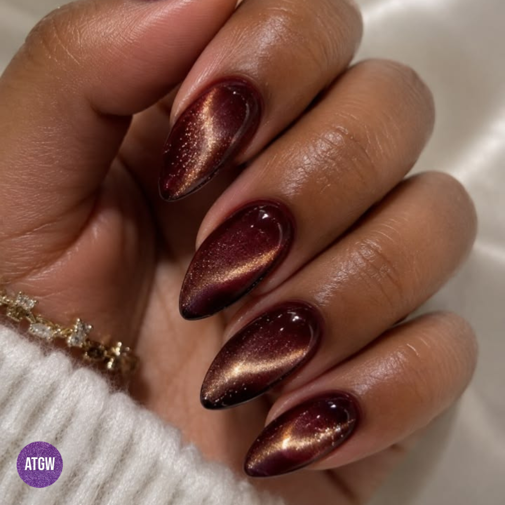 Cat eye nail design with deep burgundy base and amber glow, perfect for the fall season.