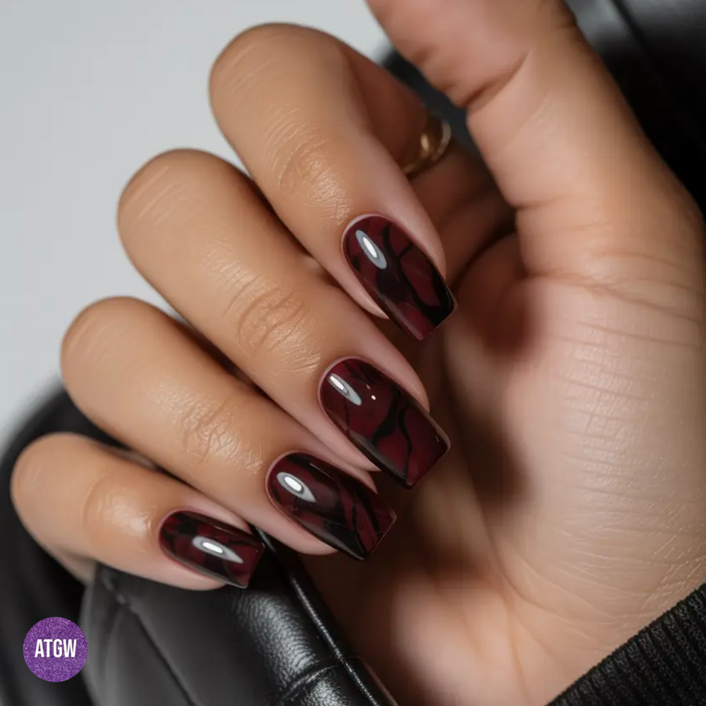 Fall nail design featuring subtle black smoke veining over a deep burgundy base.