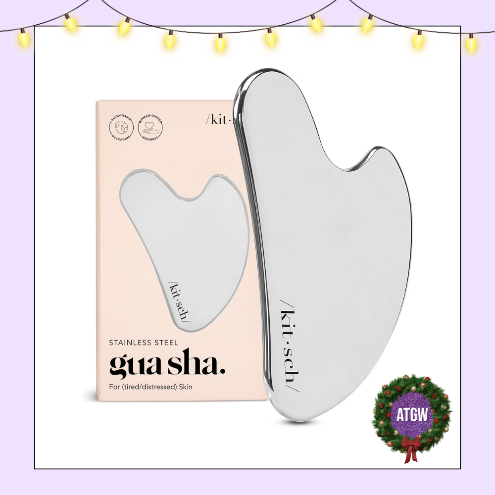 Kitsch stainless steel heart-shaped facial gua sha tool displayed beside its blush pink product packaging.