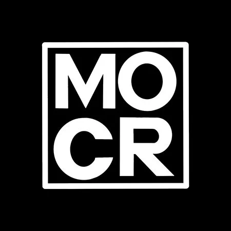 A black background with a white square outline containing the word "MOCR" in bold, uppercase letters, with "MO" on the top row and "CR" on the bottom row.