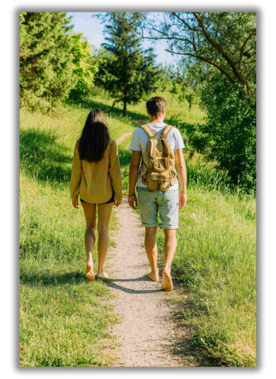 Zwei Personen gehen barfuss auf einem schmalen Weg durch die Natur – Sinnbild für Achtsamkeit, Erdung und Bewegung im Coaching.