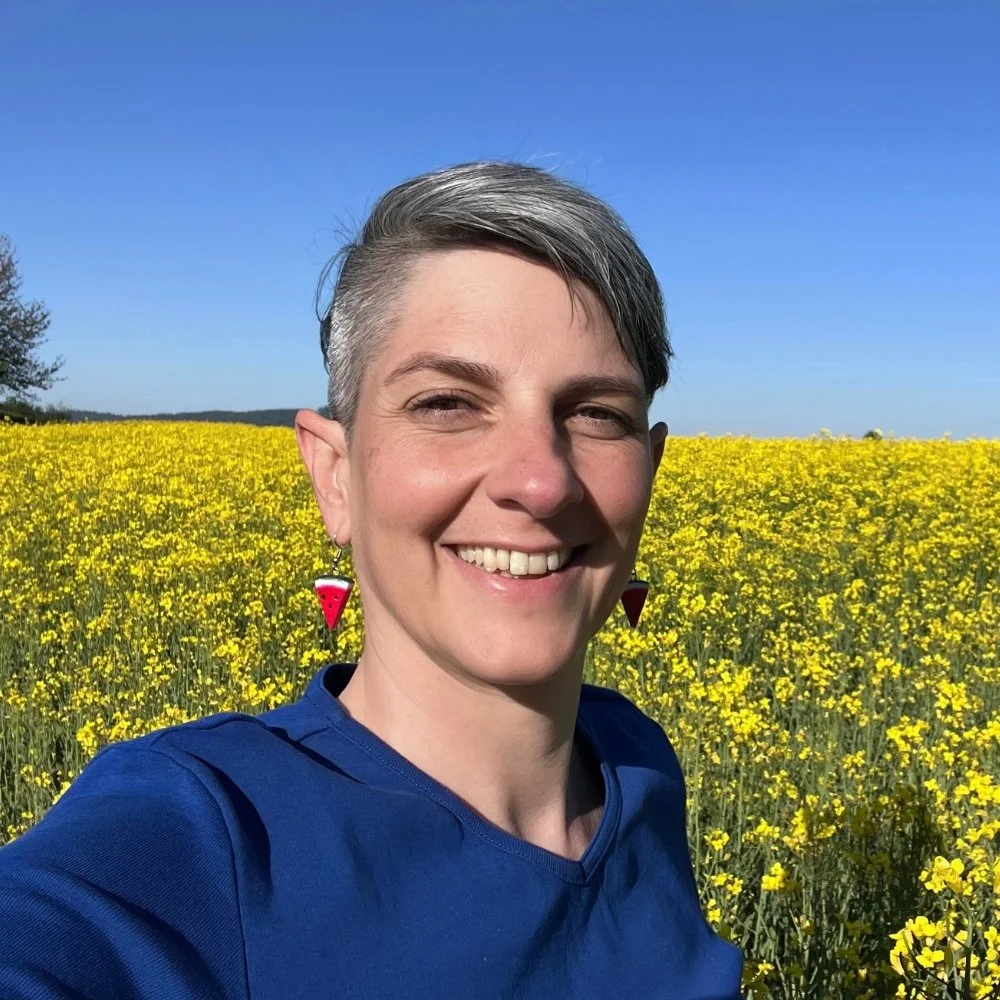 Fabienne Witschi Portrait lachend vor einem Rapsfeld