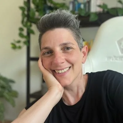 Fabienne Witschi lächelt in die Kamera und stützt das Gesicht auf der Hand - Coach für Ordnung und Barfusscoach