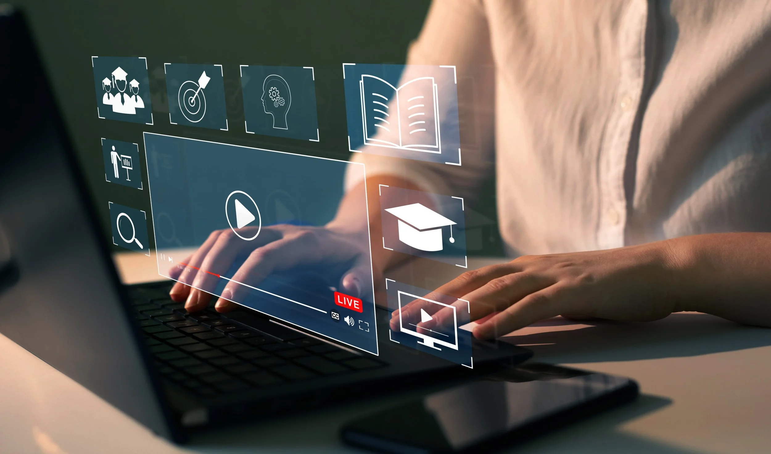 Person using a laptop with digital icons related to online learning and presentation floating above the keyboard.