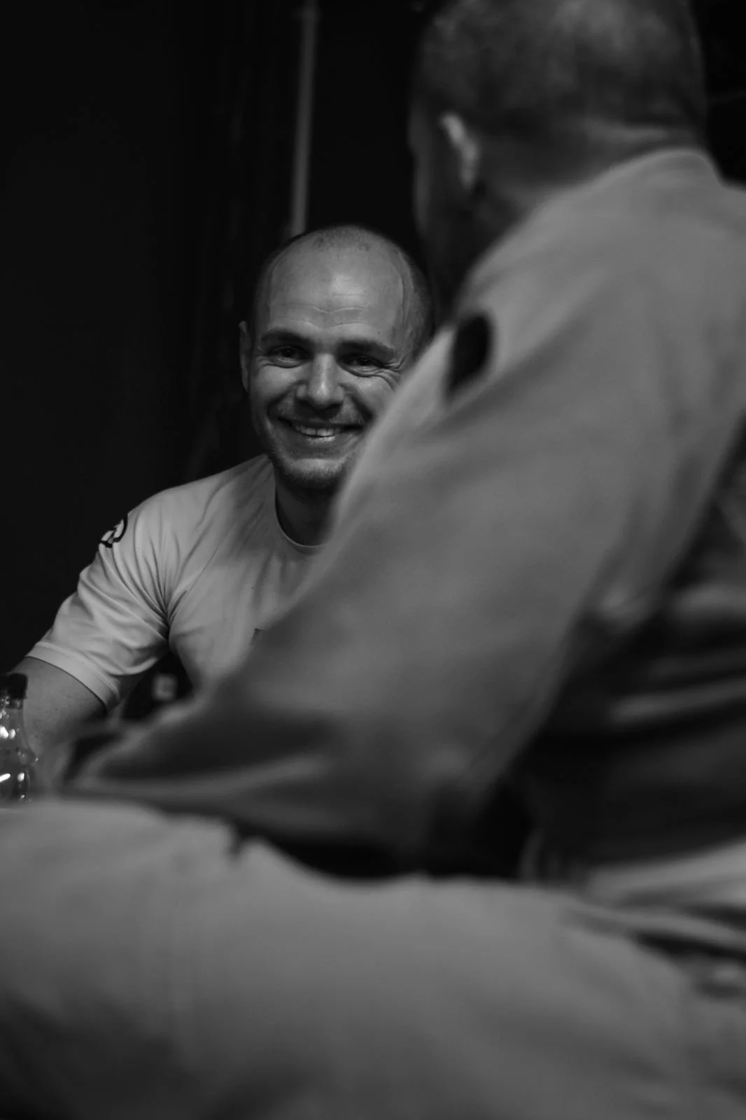 Homme souriant lors d'une conversation, vue en noir et blanc.