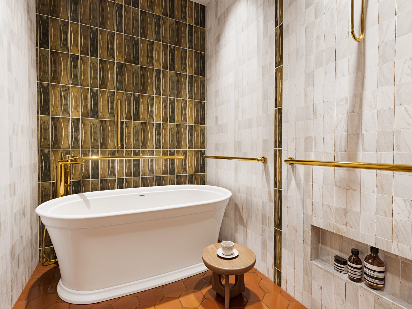 A modern bathroom with a freestanding bathtub, gold fixtures, decorative tile walls, and a small wooden stool with a cup and saucer.