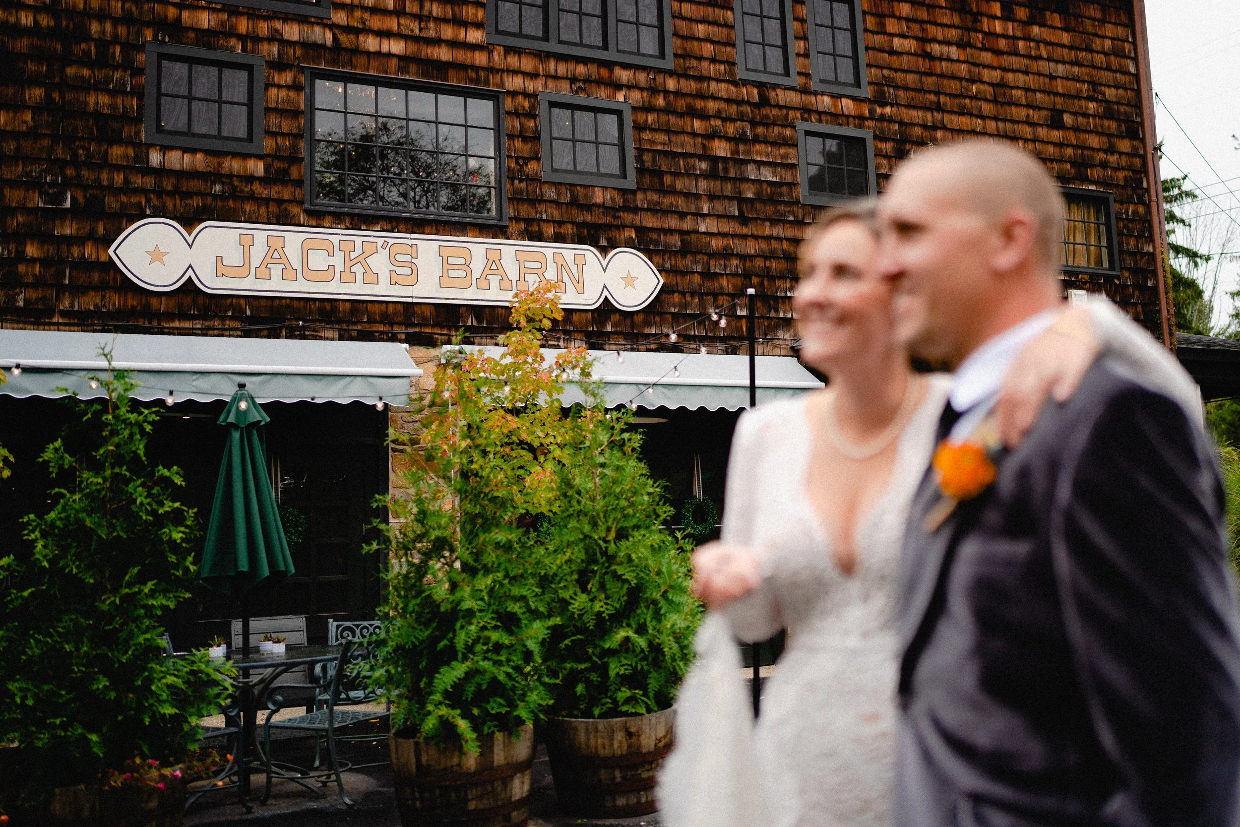 A picturesque barn setting decorated for Jack's wedding, featuring floral arrangements and rustic wooden accents.