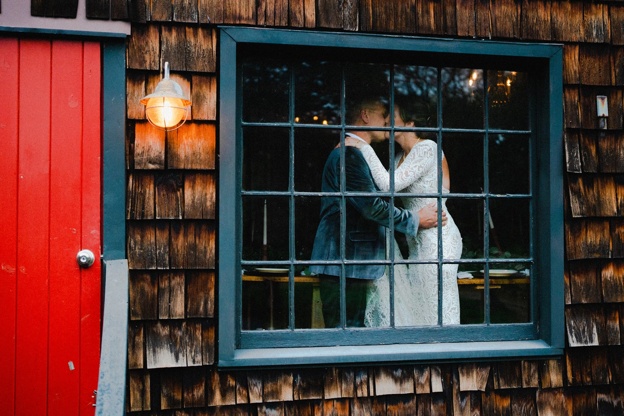 A wedding photographer capturing a couple in a romantic pose against the backdrop of New York City's skyline.