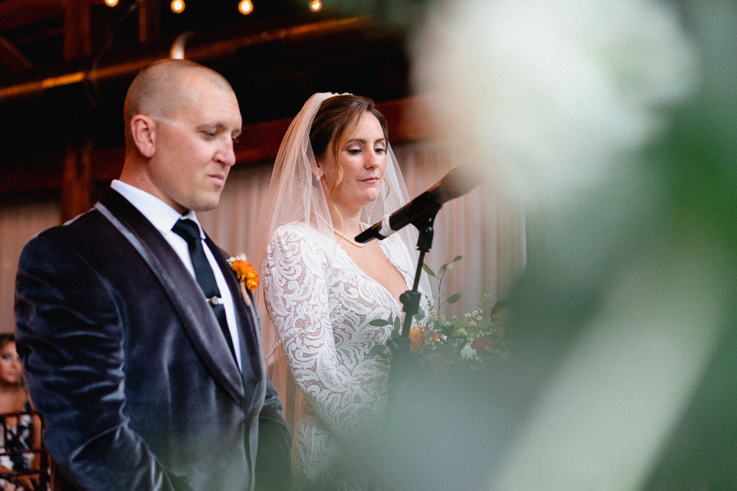 A wedding ceremony taking place at the historic old mill, surrounded by nature and decorated with flowers.