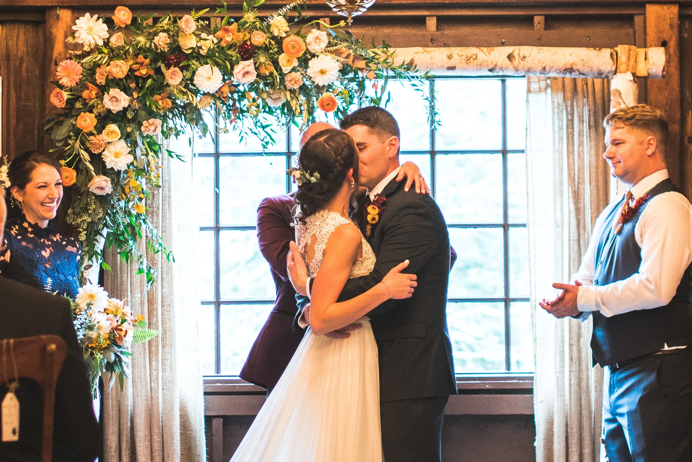 A wedding ceremony taking place at a club house, featuring guests seated and a couple exchanging vows.