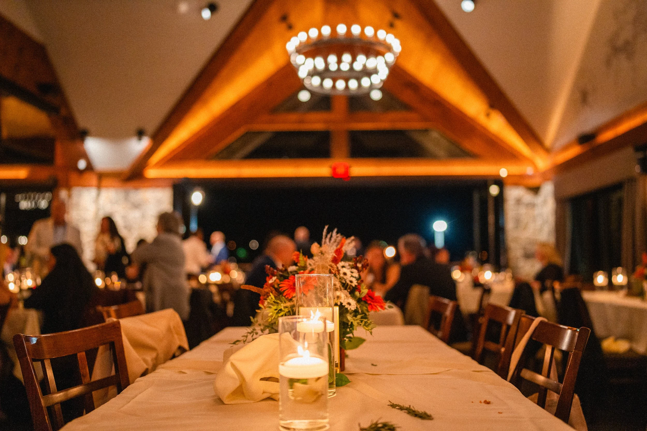 A beautifully arranged wedding reception table adorned with candles and fresh flowers, creating an elegant atmosphere.